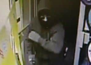 A CCTV image of the armed raider at the One Stop store in Boston.