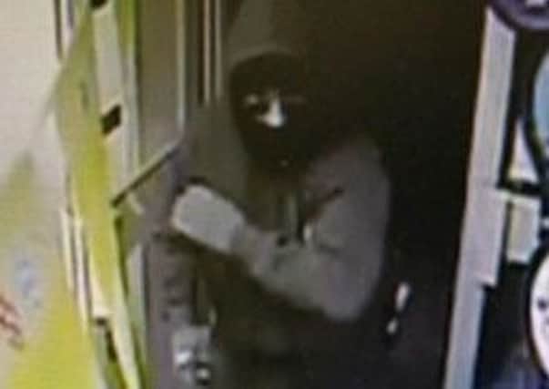 A CCTV image of the armed raider at the One Stop store in Boston.