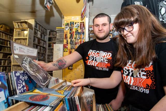 Craig Skinner, sales assistant, and Millie Skinner, volunteer, with one of the day's limited addtion Madness albums.