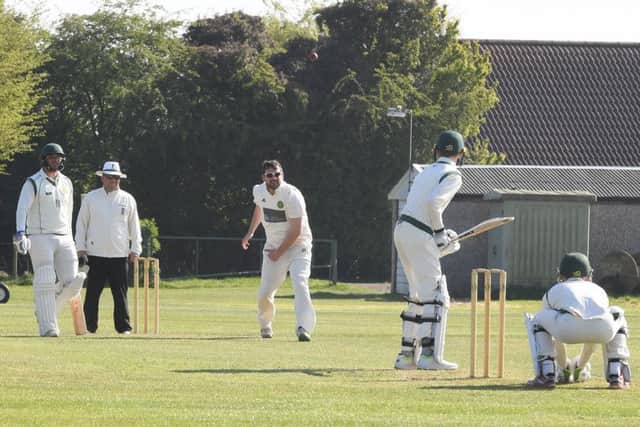 Tom Baxter sends down a delivery.