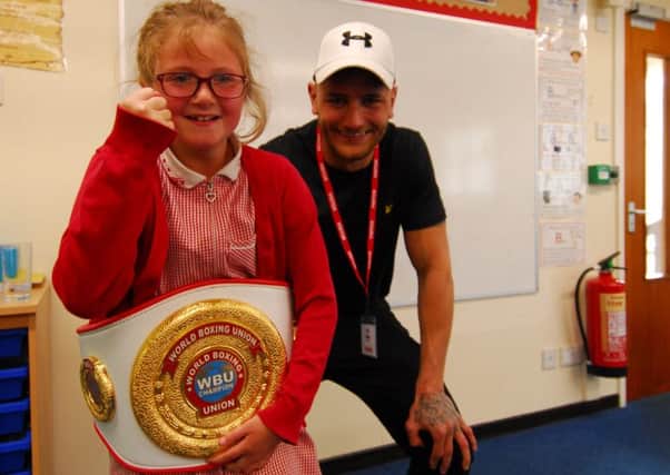 Lincoln boxer Nathan Decastro allowed Nocton School pupils to try on his WBU winners belt during his visit. EMN-190521-125636001