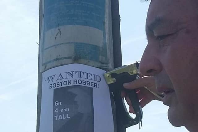 Danny Lee puts up one of his posters