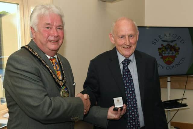 Sleaford Town Council new mayor Adrian Snookes presents the past mayor's badge to retiring mayor Grenville Jackson. EMN-190516-132911001