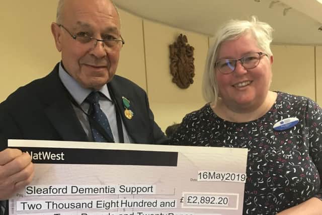 Outgoing chairman of NKDC Geoff Hazelwood presents the cheque from funds raised in his civic year to Sleaford Dementia Support secretary Bex Mezzo. EMN-190517-170057001