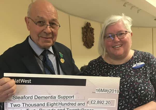 Outgoing chairman of NKDC Geoff Hazelwood presents the cheque from funds raised in his civic year to Sleaford Dementia Support secretary Bex Mezzo. EMN-190517-170057001