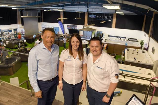 1 Stop Spas new showroom opening with ribbon cut by Rory Underwood MBE. L-R Rory Underwood with owners Melissa and Chris Brady. EMN-190527-144903001