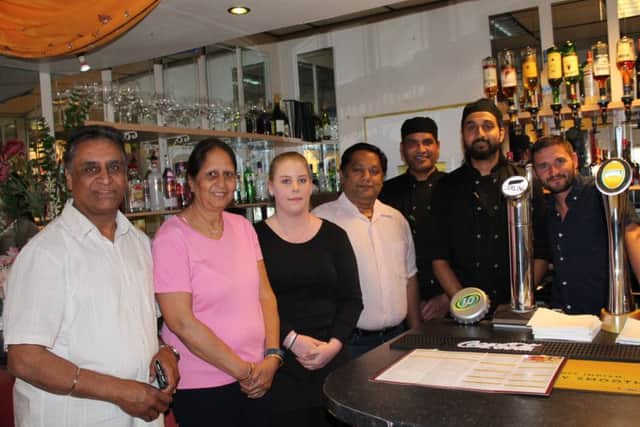 The owners, chefs, and waiting staff behind the bar at Indian Spice.