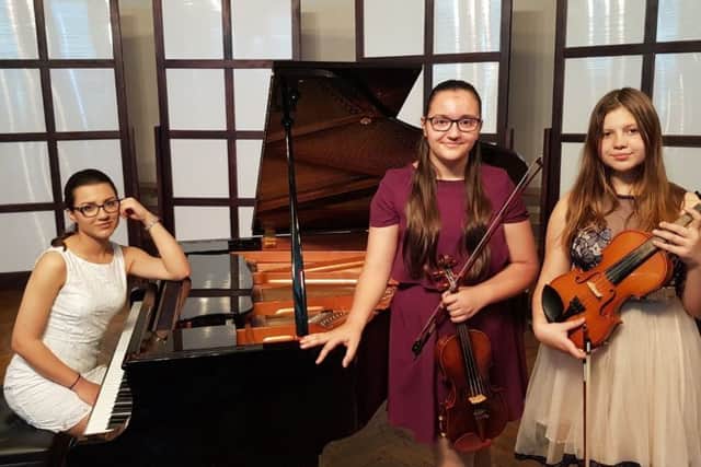 Ana Elena Gheba (18) on piano, with violinists Maria Ionela Gheba (12) and Diana Amelian (13)