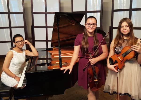 Ana Elena Gheba (18) on piano, with violinists Maria Ionela Gheba (12) and Diana Amelian (13)