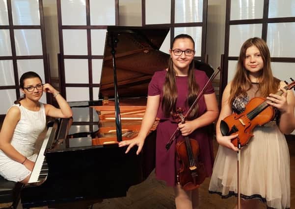 Ana Elena Gheba (18) on piano, with violinists Maria Ionela Gheba (12) and Diana Amelian (13).