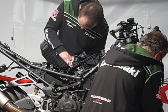 The team battles to repair the bike after Mikey's crash EMN-190530-122924002