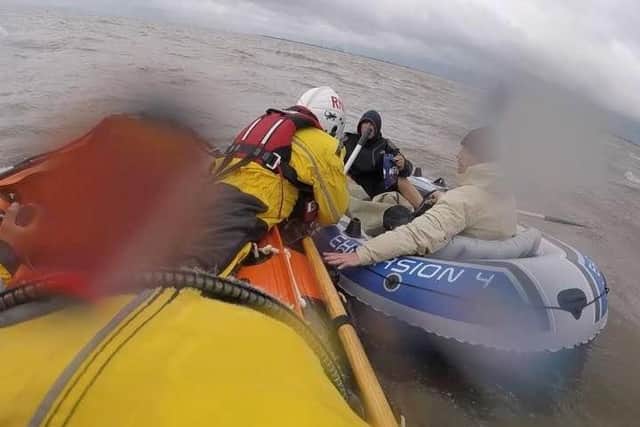 The Skegness RNLI crew reaches the two men in a dinghy blown over a mile out to sea off the coast of Chapel St Leonards.