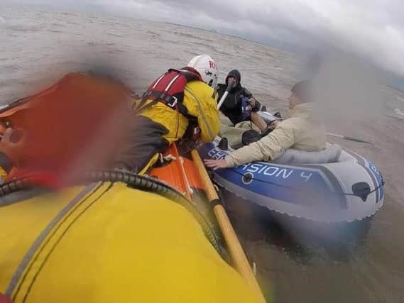 The Skegness RNLI crew reaches the two men in a dinghy blown over a mile out to sea off the coast of Chapel St Leonards.