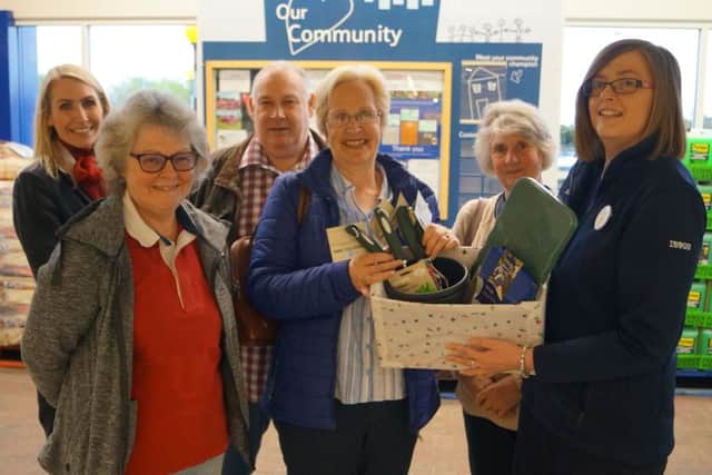 Tesco store's Katie Hubbert hands over the gardening goodies to representatives of Greenacres EMN-191106-114524001