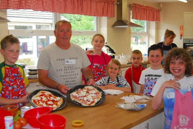 Cranwell School experience day. School caretaker Karl Kinsella shows the children how to make their own pizzas. EMN-190621-163327001