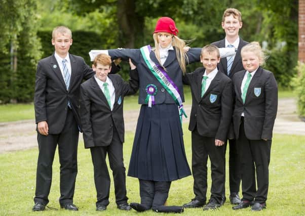 James Waumsley, Luke Motson, Levi Waumsley, Sebastian Furneaux, Phoebe Dave with a scarecrow of a Suffragette, which is on display on the Louth Tractor stand at the Lincolnshire Show.
