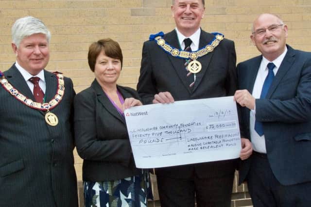 PAYMENT OF HOPE: Pictured from left are Steve Hallberg, Provincial Grand Master of Lincolnshires Mark Master Masons; Councillor Wendy Bowkett, East Lindsey District Councils member for Wainfleet, Dave Wheeler, the Freemasons Provincial Grand Master for Lincolnshire, and Paul Scott, Chairman of Lincolnshire Community Foundation with a cheque for 75,000 to help with Wainfleets recovery.