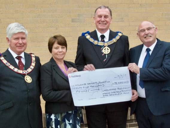 PAYMENT OF HOPE: Pictured from left are  Steve Hallberg, Provincial Grand Master of Lincolnshires Mark Master Masons; Councillor Wendy Bowkett, East Lindsey District Councils member for Wainfleet, Dave Wheeler, the Freemasons Provincial Grand Master for Lincolnshire, and Paul Scott, Chairman of Lincolnshire Community Foundation with a cheque for 75,000 to help with Wainfleets recovery.