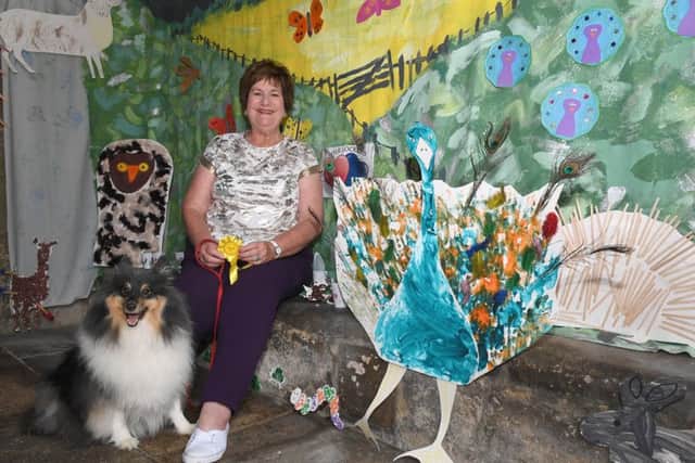 Great Hale Wildlife Festival. Church Warden Elaine Huckle with her dog Cody, with display by Little Lockets Nursery. EMN-190625-002953001