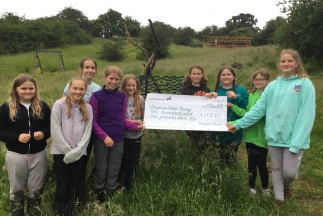 The children from Rauceby Church of England Primary School hand over the cheque at the Benjamin Adlard Primary School in Gainsborough.