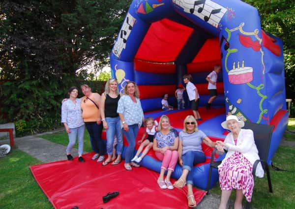 Residents, staff and friends enjoy time on the bouncy castle at the Ashdene summer fair.