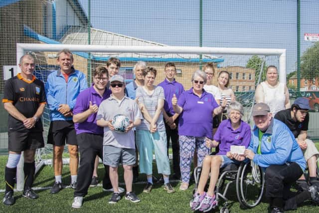 Pictured are Steve Morris and some of the Accies players handing over the cheque to Laffletics founder and leader Thelma Smith.