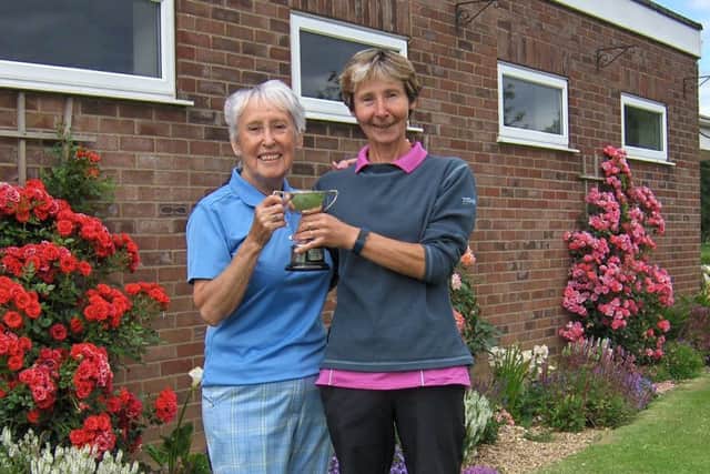 Pam Clare is presented with the cup from Vice Captain Ruth Simpson.