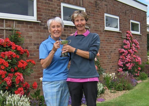 Pam Clare is presented with the cup from Vice Captain Ruth Simpson.