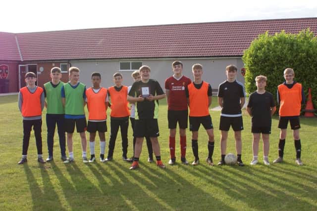 Woodhall Spa United FC under 14s proudly show off the trophy at the first training session of the new season.