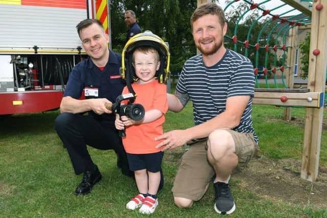 Sleaford RC School, family fun day. Firefighter Charlie O'Neill with Glen Dickson and Rowan Dickson 2. EMN-190715-232607001