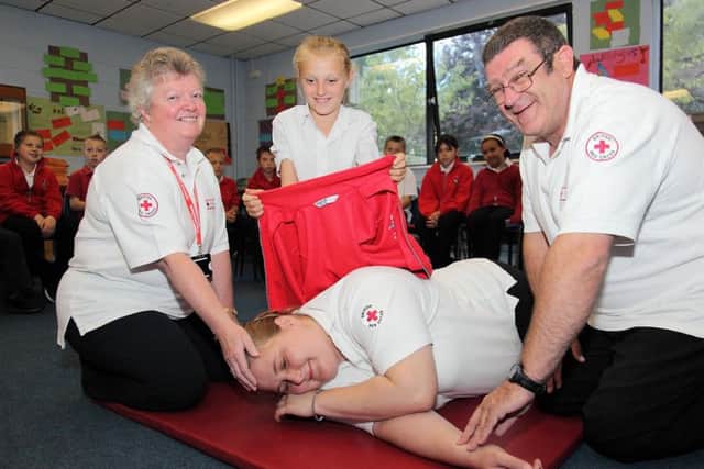 'Casualty' Ellie Stringer, centre front, being treated by British Red Cross trainer Sue Devonshire, Ellie Cunliffe, 10, and British Red Cross trainer Andy Davis.