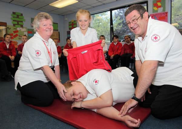 'Casualty' Ellie Stringer, centre front, being treated by British Red Cross trainer Sue Devonshire, Ellie Cunliffe, 10, and British Red Cross trainer Andy Davis.