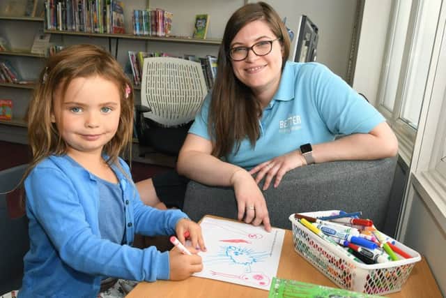 Centenary of Peace Day at Market Rasen. Annabelle Salmon 4 doing art work in the library, pictured with library manager Georgina Carr EMN-190721-220736001