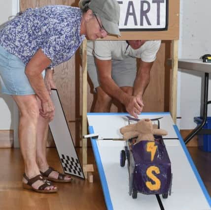 Aisby village fete with shoebox car races. Bernie and Sue Norton starting the shoebox cars EMN-190722-101305001