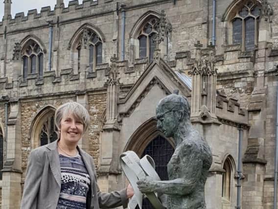 Wilkin Chapman Partner Flora Bennett outside the beautiful St James
Church, Louth with the towns Meridian Line Man  a popular draw for visitors.