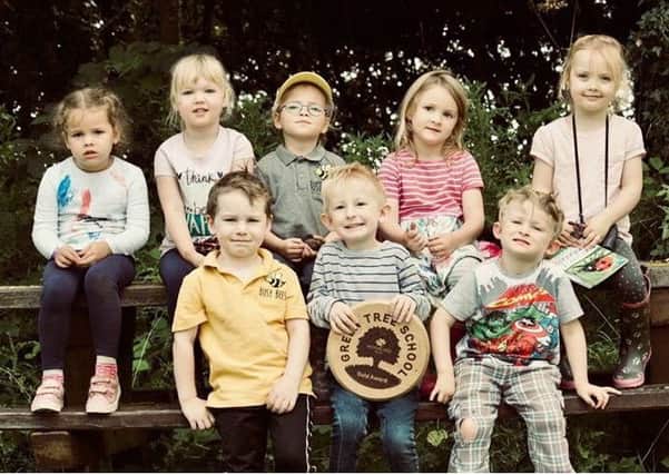 Youngsters from Busy Bees Early Years and nature Centre, with their gold award plaque from the Woodland Trust.