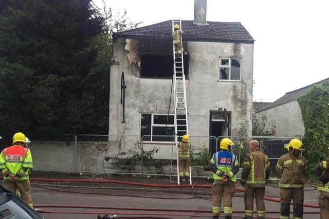 Firefighters survey the gutted building