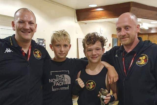 Harvey Harmon is pictured post-fight with Alfie Briggs and coaches Scott Harmon and Matthew Mooney.