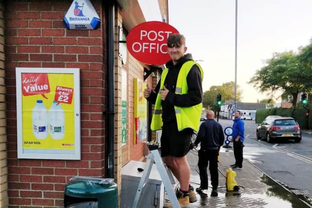 A worker installs the Post Office sign outside the Spar shop in Sutton on Sea. (Photo: Adrian Benjamin).