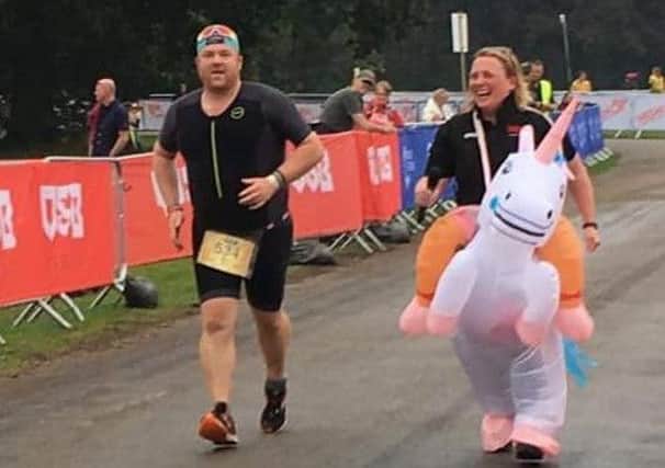 Stuart Gutteridge is cheered on to the finish by junior coach, Louise Short in fancy dress EMN-190927-114945002