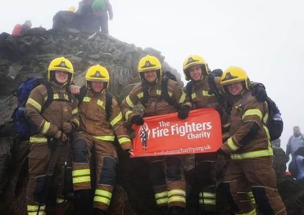 The firefighters reach the summit of Mount Snowdon in their full kit. Pictured, from left, is Ollie Baldham, Ben Gleadhill, Daniel Cheetham, Charlie O'Neil and Sam Newlyn.