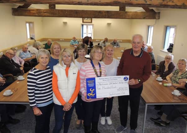 Sleaford Lionesses president Pam Kyte presents the donation of ?500 to Derek Arnold, chairman of Sleaford Parkinsons Support Group. EMN-190710-190108001