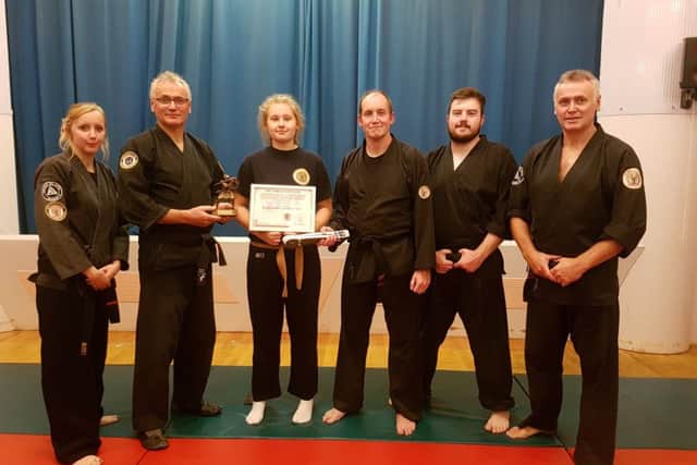 Emma Morley is pictured with Cobra Ju-Jitsu senior sensei Nick Preston, watched by Cobra dan grades.