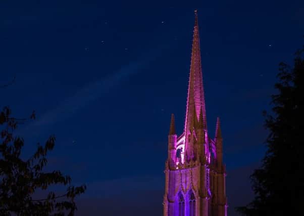 The spire of St James' Church, illuminated purple in recent years.