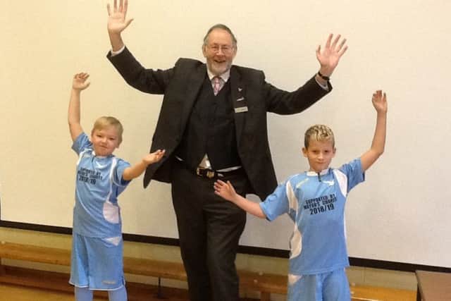 Former Mayor, Steve Palmer, alongside two Sutton on Sea pupils in their football kits.