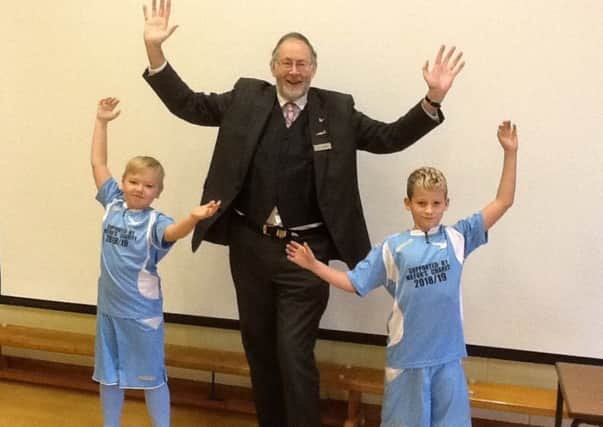 Former Mayor, Steve Palmer, alongside two Sutton on Sea pupils in their football kits.