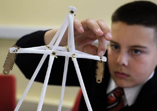 A pupil at Haven High Academy, in Boston, demonstrates the creation of a modern pylon in one of the school workshops. (Photo: John Robertson/National Grid).
