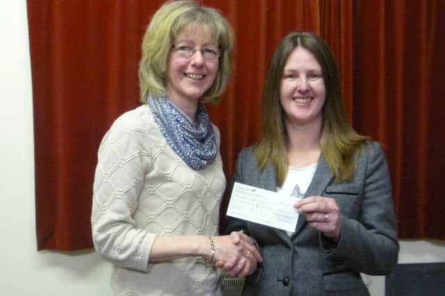 WI treasurer Barbara Pollard presents St Andrew's Hospice fundraiser Kelly Uprichard with a cheque for £125. EMN-140324-164302001