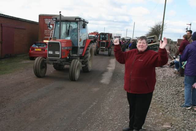 Linda Brumpton sends some of the tractor drivers on their way out of Old Railway Yard Barnetby as they set off on their sponsored tractor run in aid of Lindsey Lodge Hospice. EMN-140327-143919001