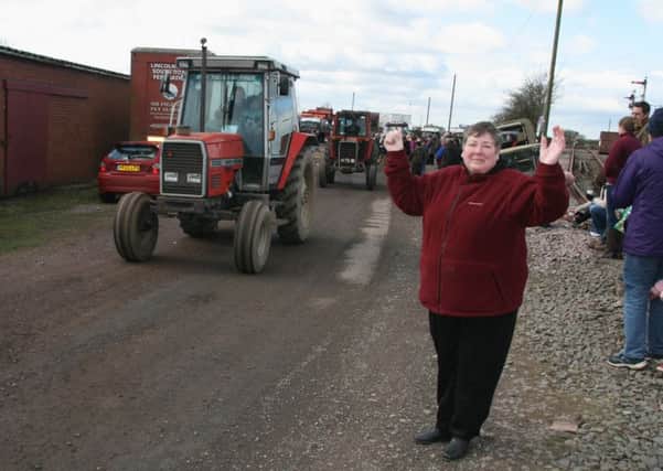 Linda Brumpton sends some of the tractor drivers on their way out of Old Railway Yard Barnetby as they set off on their sponsored tractor run in aid of Lindsey Lodge Hospice. EMN-140327-143919001